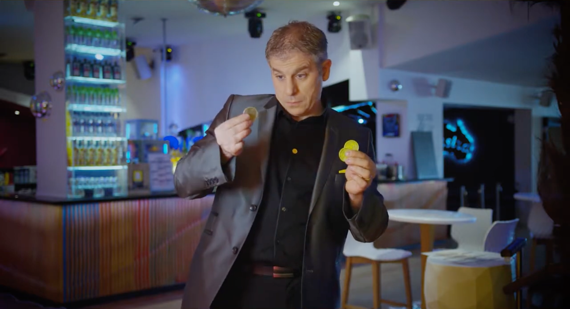 Chris Torrente réalise un effet de magie avec plusieurs pièces apparaissant entre ses mains.