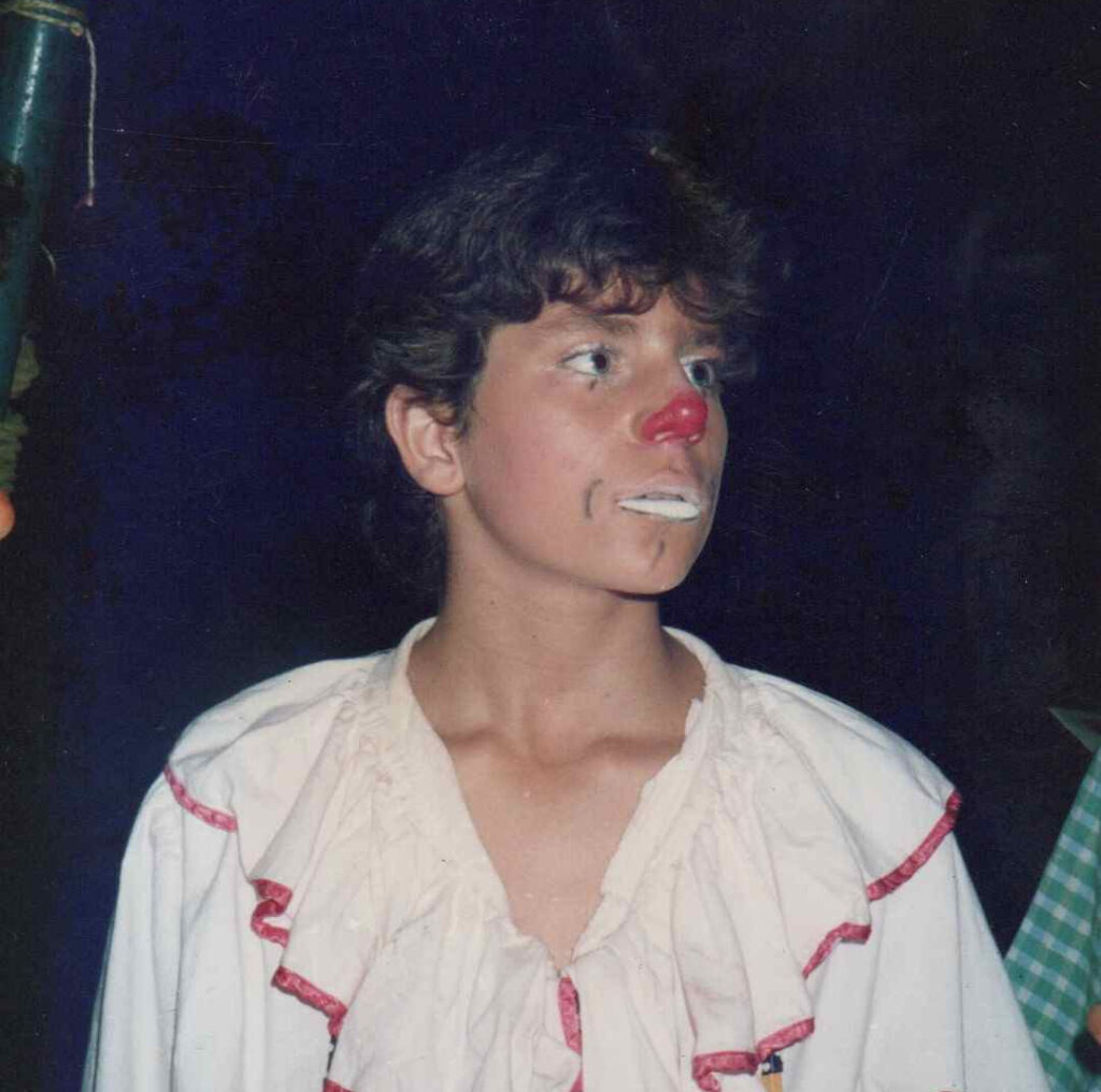 Chris Torrente adolescent lors d'un spectacle de cirque, incarnant un personnage de clown sur scène.
